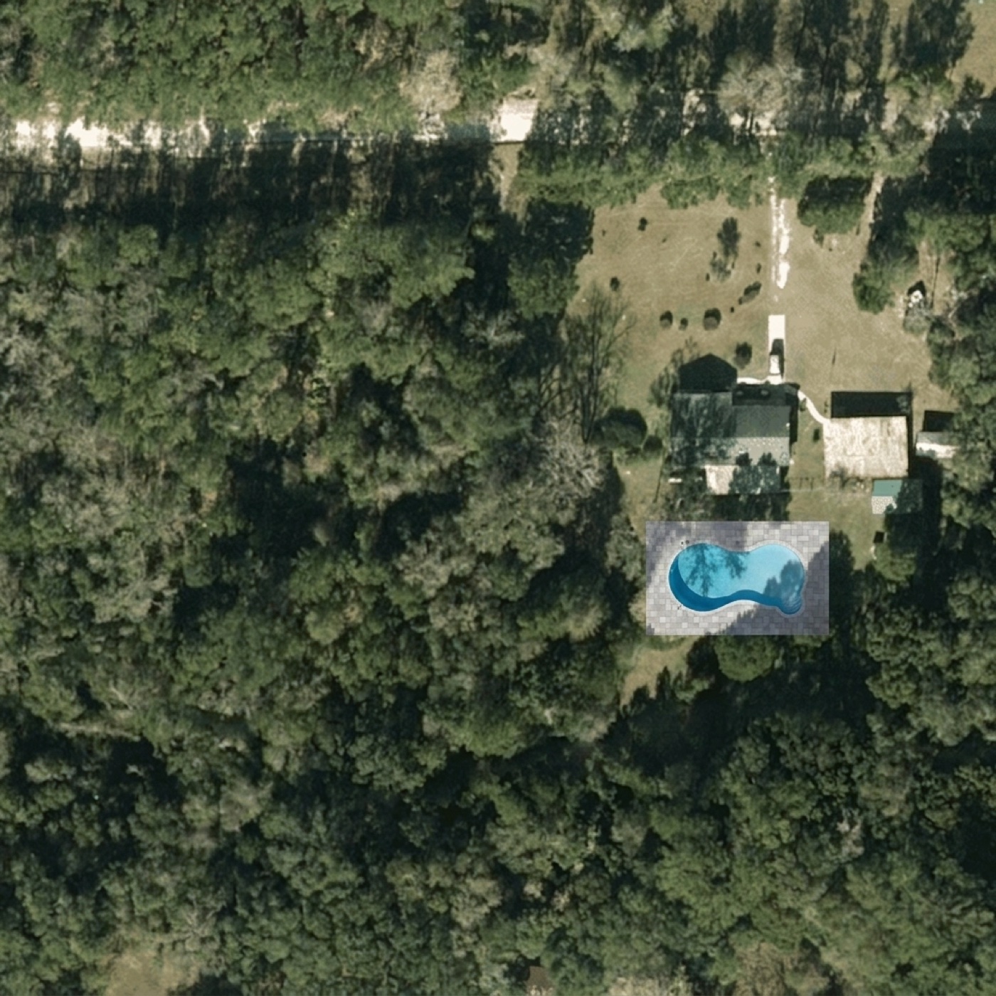 The same aerial photo with a free-form pool and paver deck rendered behind the house